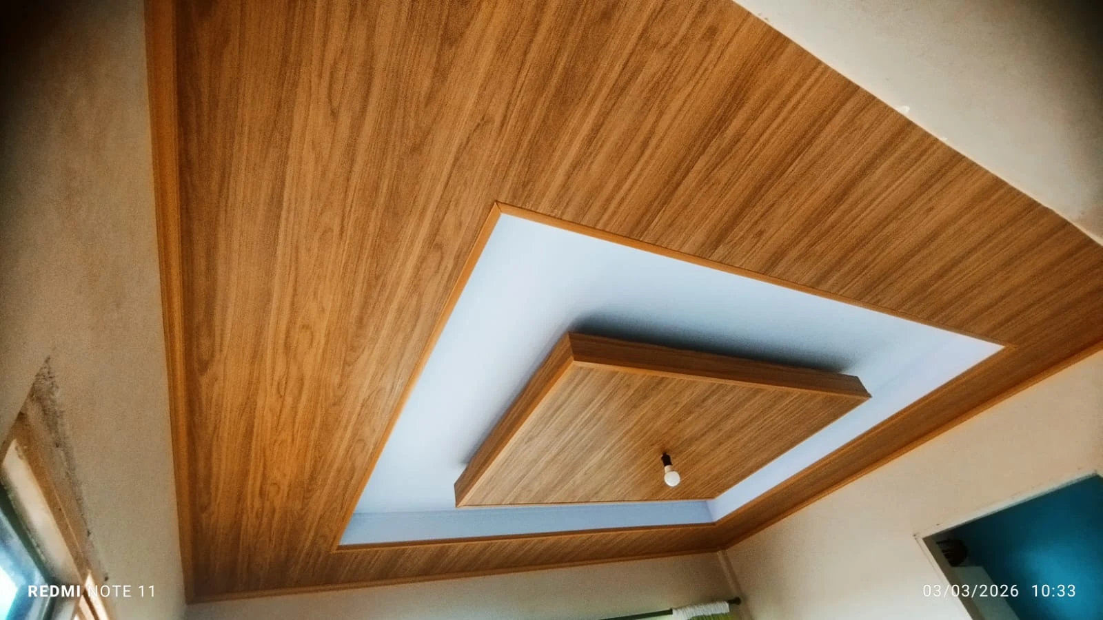 Detalhe de forro amadeirado com desenho central branco